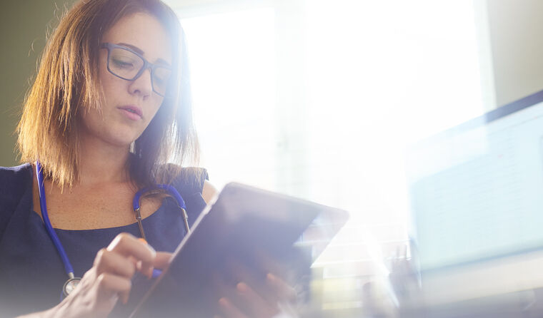 Female GP looking on tablet